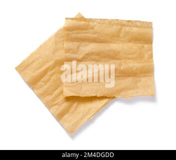 Backpapier isoliert. Zerknitterte Stücke braunes Pergament oder Backpapier auf weißem Hintergrund. Draufsicht. Konstruktionselement. Stockfoto