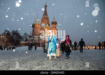 Moskau, Russland. Am 18.. Dezember 2022 führt Ein Reiseleiter, der ein Schneemädchen-Kostüm trägt, eine Kindertour am St. Basilius-Kathedrale im Zentrum von Moskau, Russland Stockfoto