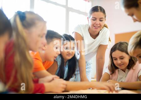 Lehrer und Schüler spielen Brettspiel in der Schule Stockfoto