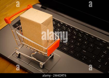 Ein Miniatur-Einkaufswagen auf einem Laptop - Online-Shopping-Konzept Stockfoto