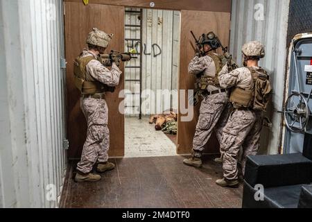 USA Marines, die dem Flotten-Anti-Terror Security Team Central Command (FASTCENT) und den Küstenwachmännern des Maritime Engagement Teams zugeteilt sind, tauschen Fähigkeiten und Taktiken während eines Besuchs, Vorstands, Such- und Beschlagnahmungssachenaustauschs im Rahmen der Übung Intrepid Maven 23,1 an Bord der Naval Support Activity Bahrain am 14. Dezember aus. Intrepid Maven ist eine bilaterale Übung zwischen den US-Streitkräften und Bahrain, um unsere Beziehungen zu den alliierten Nationen in den USA zu trainieren und zu stärken Einsatzgebiet des Zentralkommandos. (USA Marinekorps Foto von Staff Sgt. Victor A. Mancilla) Stockfoto