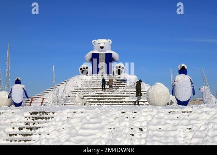 Großer Eisbär steht im Winter auf der Straße der Stadt, festliches Spielzeug. Die Leute gehen unter Weihnachtsdekorationen und Installationen. Dnipro, Ukraine 2022-01-02 Stockfoto