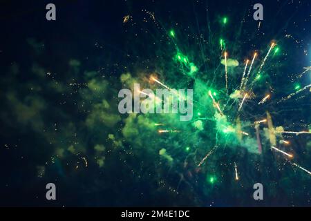 Grünes, helles Feuerwerk vor dem Hintergrund des Nachthimmels. Stockfoto