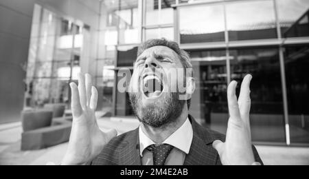 Frustriert schreiender bärtiger Geschäftsmann in formeller Klage, Konkurs Stockfoto