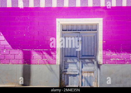 Rustikale alte Holztür mit strukturierter wandfassade aus lehmziegeln in Cusco, Peru Stockfoto