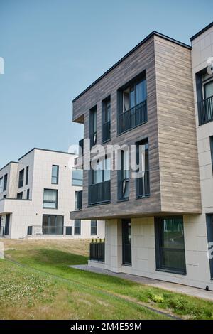 Vertikale Weitwinkelaufnahme von Wohngebäuden in einem modernen Wohnkomplex, beleuchtet durch Sonnenlicht Stockfoto