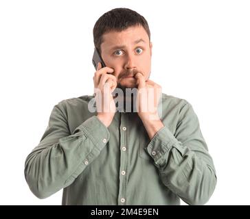 Ein hübscher Mann, der Nägel beißt und mit dem Handy spricht, auf weißem Hintergrund Stockfoto