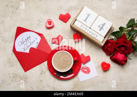 Umschlag mit Text HAPPY VALENTINE's DAY, Kalender, Tasse Latte, Herzen und Rosen auf Grunge Hintergrund Stockfoto