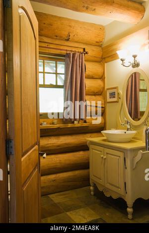 Buttermilchholz Waschtisch und Schüssel Waschbecken im Hauptbadezimmer im 2003 gebauten Blockhaus im Cottage Stil. Stockfoto