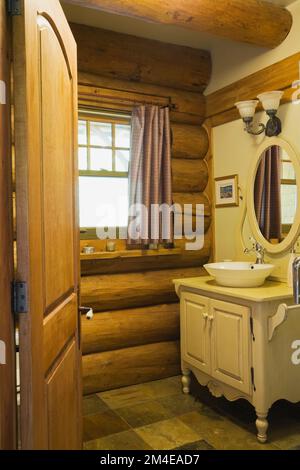 Buttermilchholz Waschtisch und Schüssel Waschbecken im Hauptbadezimmer im 2003 gebauten Blockhaus im Cottage Stil. Stockfoto