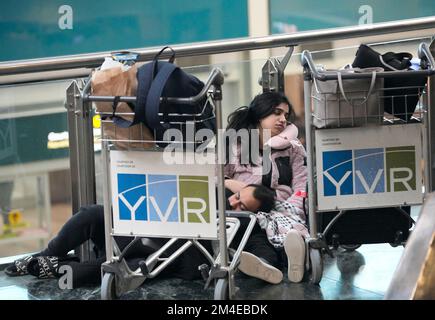 Richmond, Kanada. 20.. Dezember 2022. Am 20. Dezember 2022 schlafen die Menschen auf dem Boden des Vancouver International Airport in Richmond, British Columbia, Kanada. Tausende von Reisenden saßen am Dienstag am Vancouver International Airport fest, da viele Flüge aufgrund des Schneesturms gestrichen oder verspätet wurden. Kredit: Liang Sen/Xinhua/Alamy Live News Stockfoto