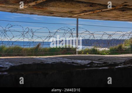 In einem der deutschen Waffenplatzierungs-Bunker am Omaha Beach mit Blick auf den Ärmelkanal. Stockfoto