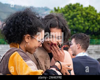 Medellin, Antioquia, Kolumbien - 14 2022. November: Junge kolumbianische Frau mit schwarzem Haar zeigt ihre Fotos einer wunderschönen Frau mit langen Nägeln Stockfoto