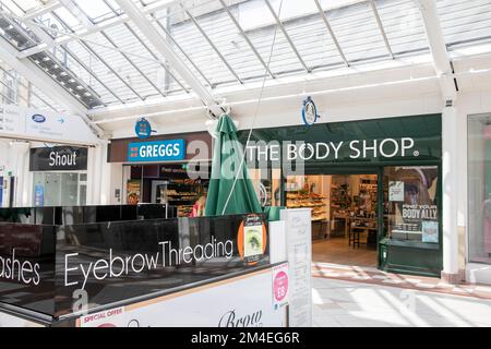 Body Shop Beauty Products Store und Greggs Bakers Store im Mill Gate Shopping Centre im Stadtzentrum von Bury, Greater Manchester, England, UK Stockfoto