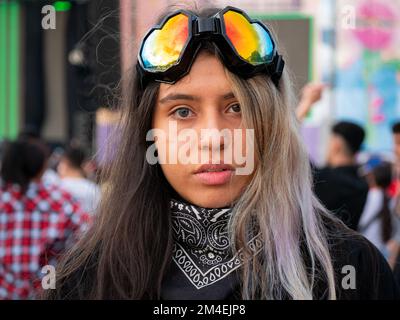 Medellin, Antioquia, Kolumbien - November 14 2022: Portrait einer jungen kolumbianischen Frau mit Heterochromie trägt eine farbige Brille in Form eines Herzens Stockfoto