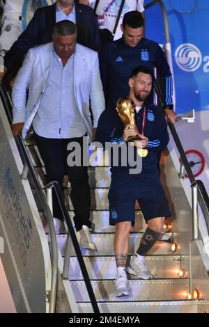 (221221) -- BUENOS AIRES, 21. Dezember 2022 (Xinhua) -- Argentiniens Lionel Messi (Front) hält die Trophäe für die FIFA-Weltmeisterschaft nach der Ankunft am internationalen Flughafen Ezeiza, nachdem das Team das Finale der FIFA-Weltmeisterschaft 2022 in Buenos Aires, der Hauptstadt Argentiniens, am 20. Dezember 2022 gewonnen hat. (TELAM/Handout über Xinhua) Stockfoto