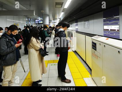 Japanische Passagiere warten auf den Einstieg in die U-Bahn in Tokio, Japan. Stockfoto