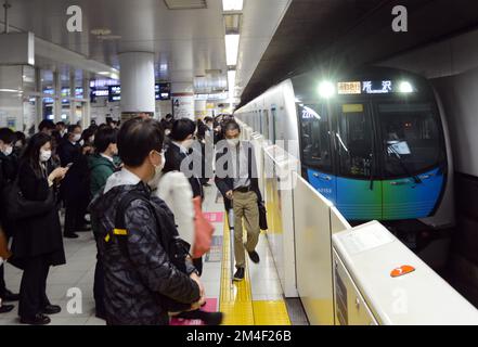 Japanische Passagiere warten auf den Einstieg in die U-Bahn in Tokio, Japan. Stockfoto