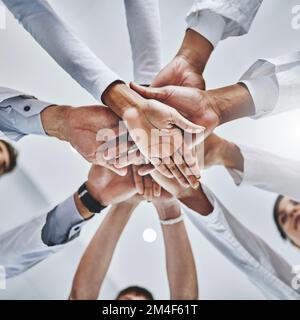 Geschickte Hände, die für Ihr Wohlbefinden verantwortlich sind. Low-Angle-Aufnahme eines vielfältigen Ärzteteams, das ihre Hände in einem Krankenhaus zusammenfasst. Stockfoto