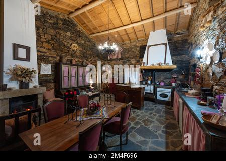 Offene Küche und Wohnzimmer in altem Retro-Haus mit Schiefermauern in einem Dorf in Portugal, Europa Stockfoto