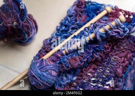 Nahaufnahme von Holzstricknadeln und bunten Wollgarnen Stockfoto