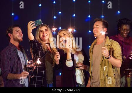 Wir lieben es, Selfies zu machen, wenn es Party ist. Eine Gruppe von Freunden macht ein Selfie, während sie Spaß in einem Nachtclub haben. Stockfoto
