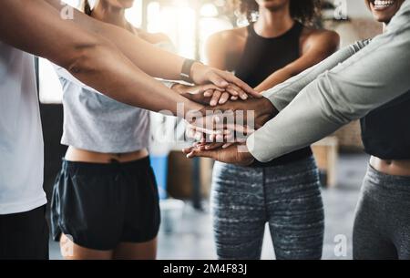 Mach mit bei der Fitness-Revolution. Eine Gruppe junger Menschen, die sich in einem Fitnessstudio solidarisch zusammentun. Stockfoto