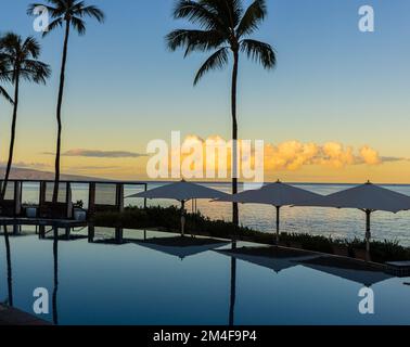 Reflexionen des Sonnenuntergangs am Infinity Pool neben der Küste, Wailea Beach, Wailea, Maui, Hawaii, USA Stockfoto