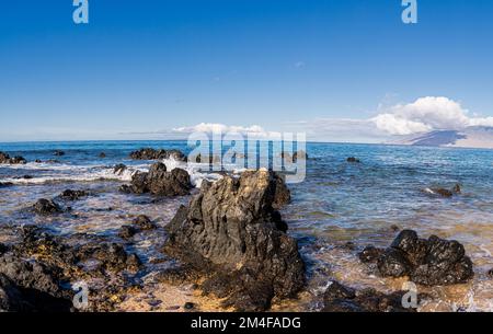 Wellen über Lavafeldern am Keawakapu Beach, Maui, Hawaii, USA Stockfoto