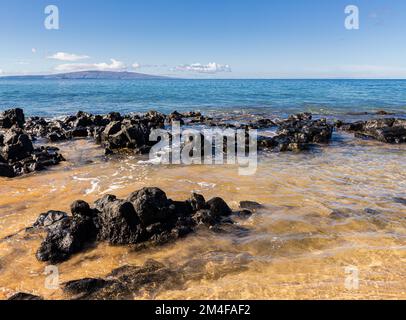 Wellen über Lavafeldern am Keawakapu Beach, Maui, Hawaii, USA Stockfoto