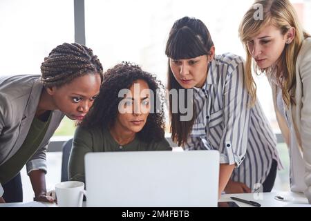 Wir alle konzentrierten uns darauf, die Aufgabe zu erledigen. Eine Gruppe von Geschäftsfrauen, die im Büro arbeiten. Stockfoto