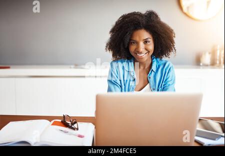 Gestalten Sie Ihre eigene Zukunft unabhängig. Eine attraktive junge Frau, die zu Hause an ihrem Laptop arbeitet. Stockfoto