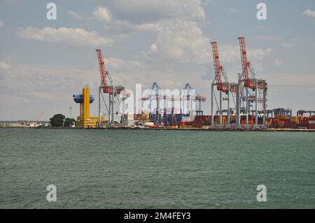 Odessa, Ukraine. 22. Juli 2021. Kräne im Schwarzmeerhafen am Himmel entladen Stockfoto