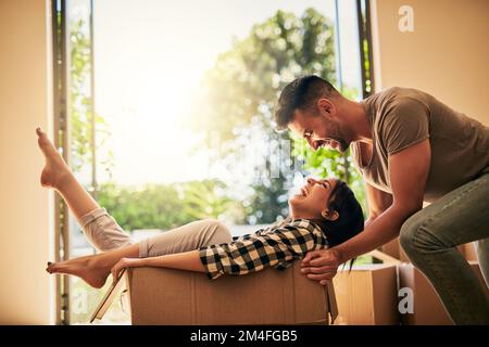 Das macht so viel Spaß. Ein junges Paar, das Spaß hat, während es in seine neue Wohnung zieht. Stockfoto
