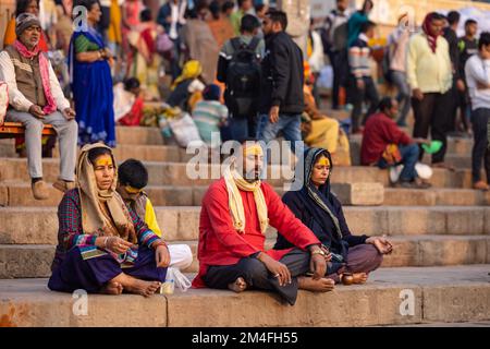 Varanasi, Indien - 2022. November: Touristen führen Rituale zusammen mit Brahminern im Dashwamedh ghat in varanasi am Wintermorgen durch. Stockfoto