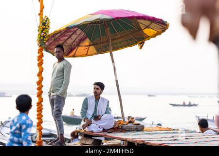 Varanasi, Indien - 2022. November: Touristen führen Rituale zusammen mit Brahminern im Dashwamedh ghat in varanasi am Wintermorgen durch. Stockfoto