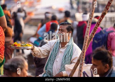 Varanasi, Indien - 2022. November: Touristen führen Rituale zusammen mit Brahminern im Dashwamedh ghat in varanasi am Wintermorgen durch. Stockfoto