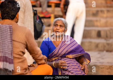 Varanasi, Indien - 2022. November: Touristen führen Rituale zusammen mit Brahminern im Dashwamedh ghat in varanasi am Wintermorgen durch. Stockfoto