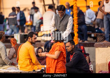 Varanasi, Indien - 2022. November: Touristen führen Rituale zusammen mit Brahminern im Dashwamedh ghat in varanasi am Wintermorgen durch. Stockfoto