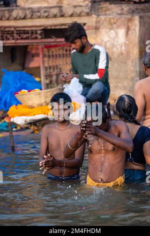 Varanasi, Indien - 2022. November: Touristen führen Rituale zusammen mit Brahminern im Dashwamedh ghat in varanasi am Wintermorgen durch. Stockfoto