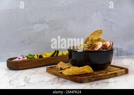 Avocado, Zwiebeln und Koriander zu Fleisch im Saft, typisch mexikanisches Essen mit Stein- und Holzhintergrund, mexiko-lateinamerika Stockfoto