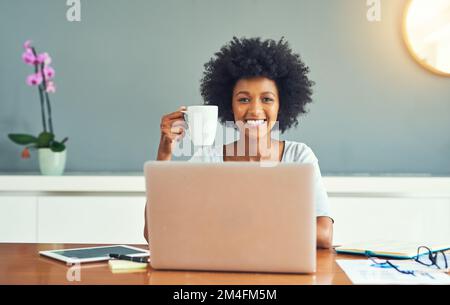 Mit dieser Tasse Kaffee bin ich startklar. Gekürztes Porträt einer attraktiven jungen Geschäftsfrau, die zu Hause arbeitet. Stockfoto