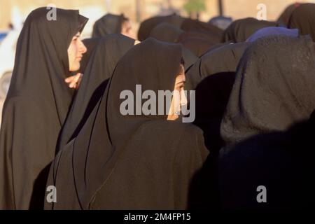 Frauen im Iran sind gesetzlich gezwungen, die Tschaddor, den schwarzen Umhang, der die Frauen fast vollständig abdeckt. Stockfoto