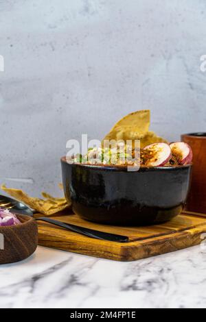 mexikanisches Frühstück, Chilaquiles mit Eiern und getoastetem Brot, Chorizo de un costado Deep Dish Stockfoto