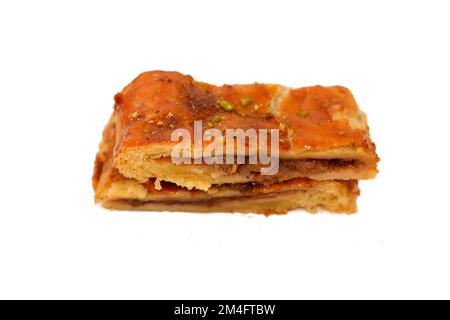 Apfelkuchen gefüllt mit cremigem Apfel, Zimt und süßem Honigsirup und garniert mit Pistazien, köstlicher süßer gebackener Apfelkuchen, fertig Stockfoto