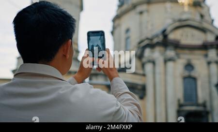 Rückblick Unbekannter Tourist reist in Europa und fotografiert Wahrzeichen mit der Kamera eines männlichen Bloggers mit Smartphone Stockfoto