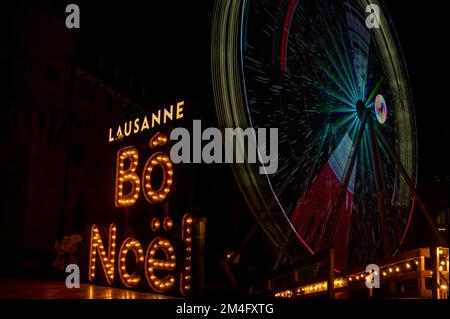 Bei Nacht rotierendes Fährrad mit Lichtern im Vergnügungspark. Bo Light Christams Festival in Lausanne, Schweiz. Stockfoto