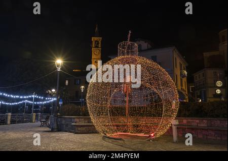 Laveno, Italien - 12-20-2022: Große Kugel, beleuchtet von farbigen Weihnachtslichtern in Laveno Stockfoto