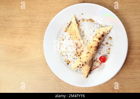 Original Käsekuchen mit Heidelbeeren auf Teller auf Holz Stockfoto