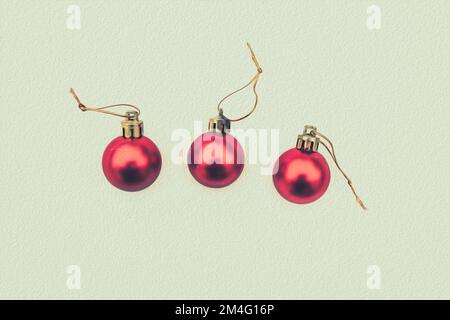 Konzept der Postkarte mit schneebedeckten Weihnachtskugeln, drei roten Kugeln Stockfoto